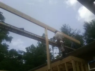 Carpenter setting a ridge beam over a new addition frame — Ice Dam Removal by Roofing Brothers in Rock Falls