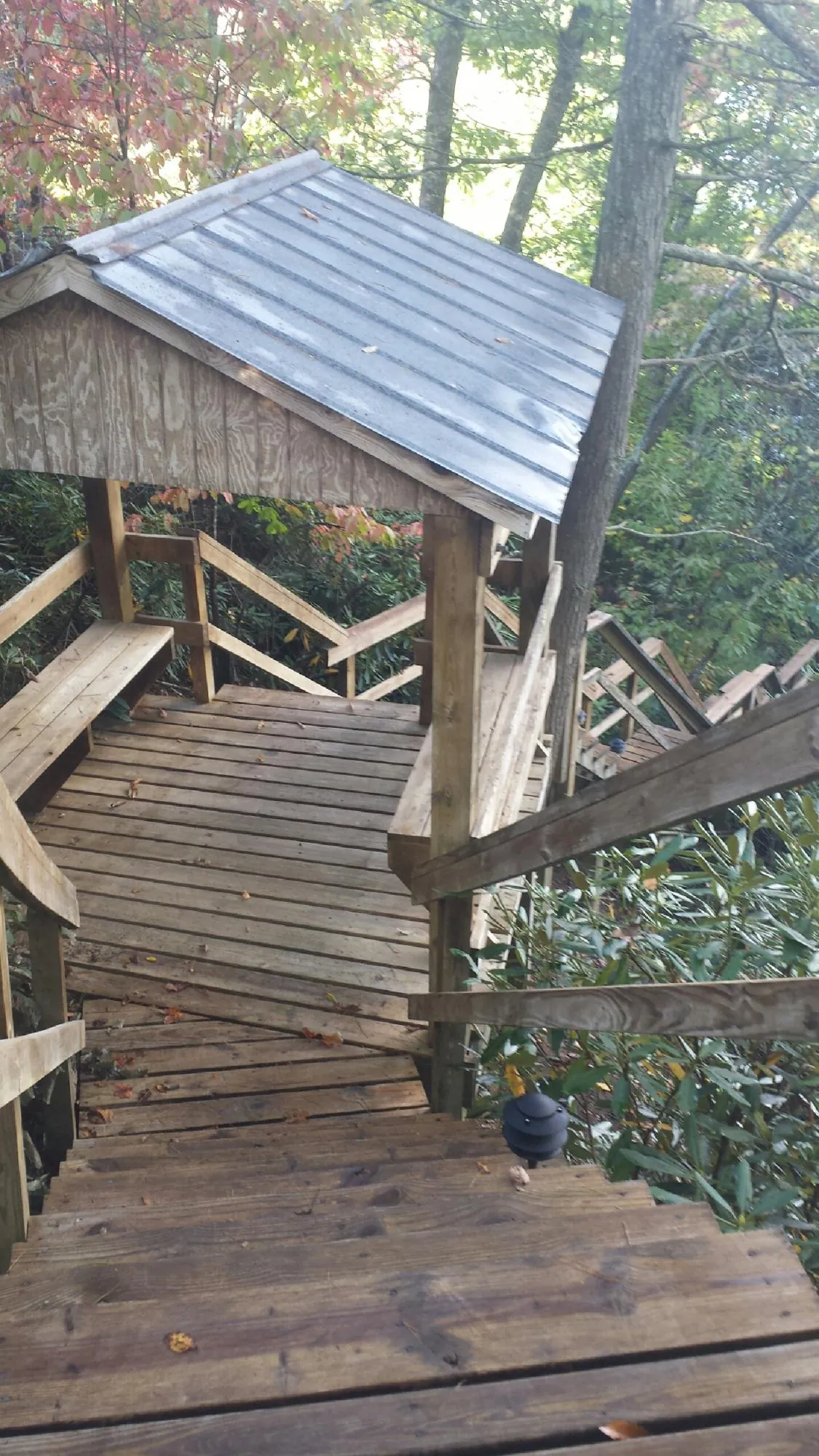 Metal roofed shelter over wooden steps on a wooded walkway — Skylight Repair & Installation work by our crew in Rock Falls
