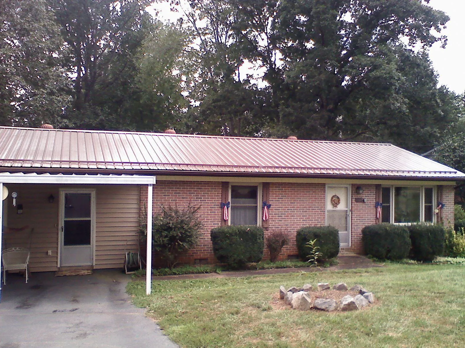 Bronze metal roof and carport on a brick ranch home — Roof Repair work by our crew in Rock Falls